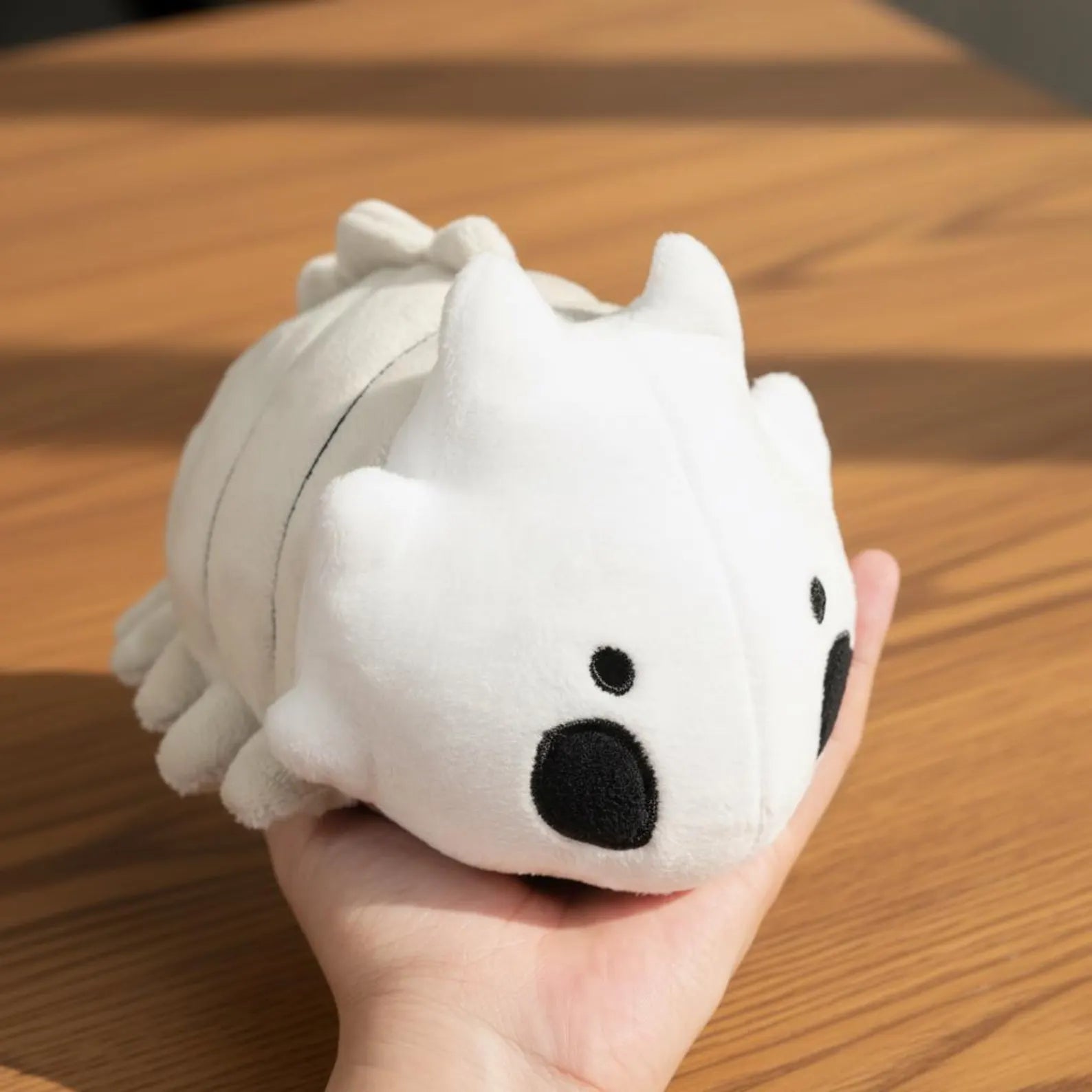 The Bell Beast Plush Toy sitting on a collector's shelf or gaming chair, ready for display.