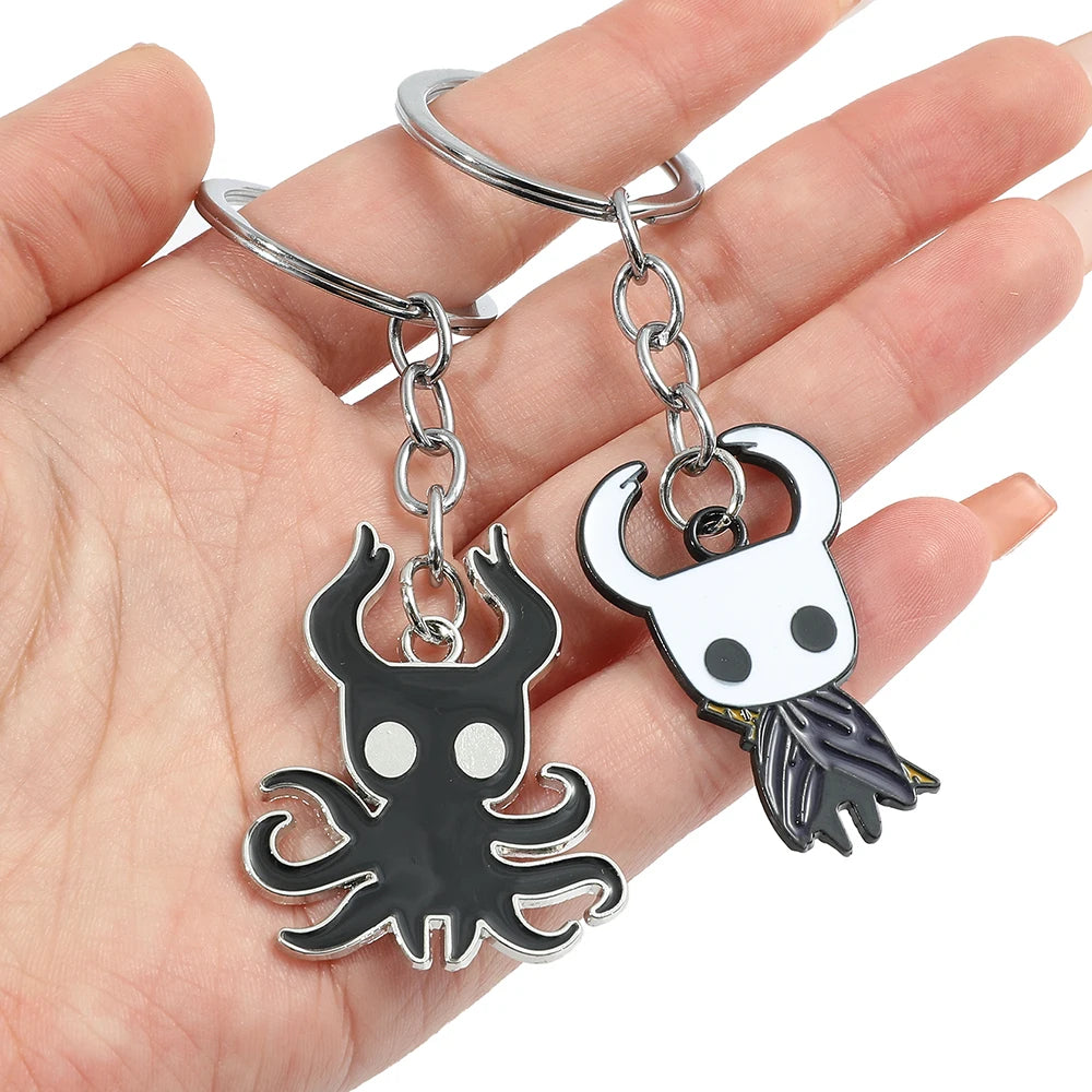 A hand holding the cute Hollow Knight keyring to show its size.