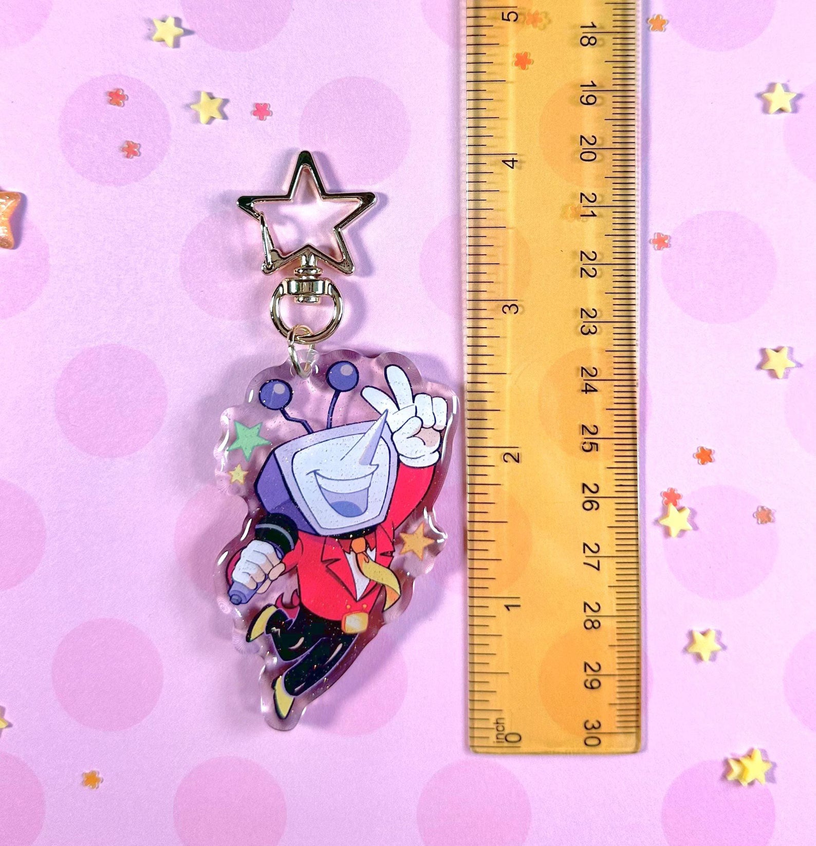 Tenna Deltarune Glitter Keychain held next to a key or coin for size reference, highlighting its scale.