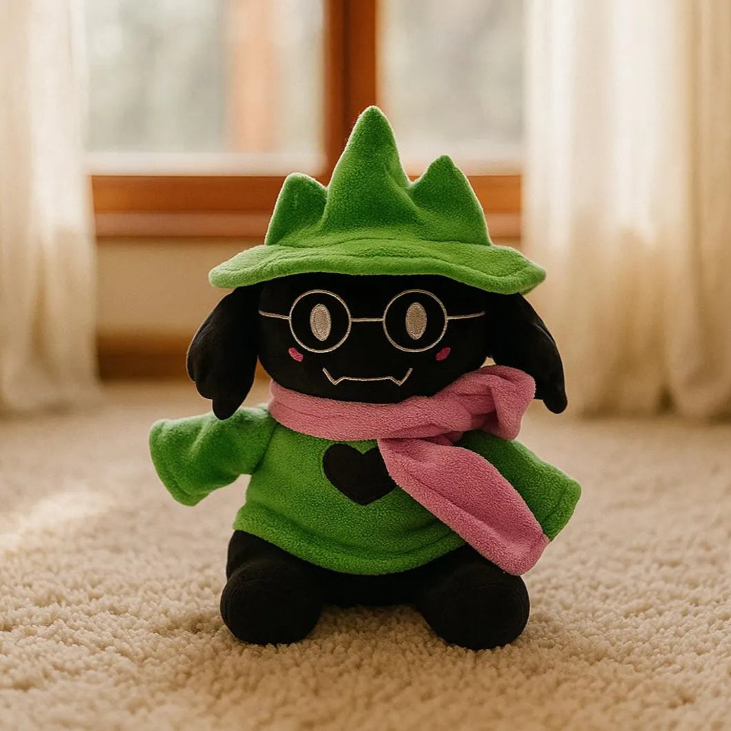 Ralsei Plush toy with a green outfit and pink scarf on a carpeted floor.