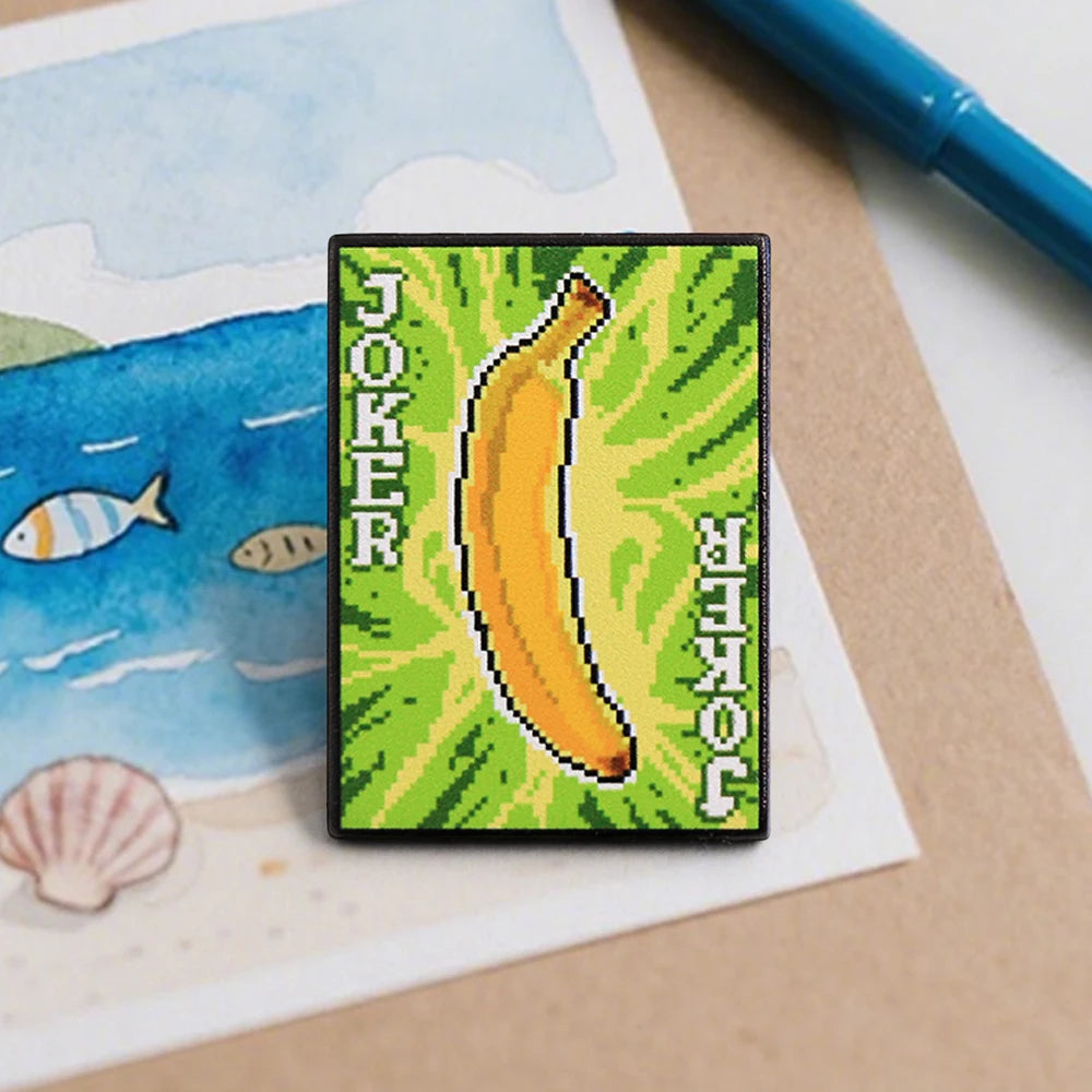Angled shot showing the gold plating and shiny hard enamel finish of the Banana Joker pin.