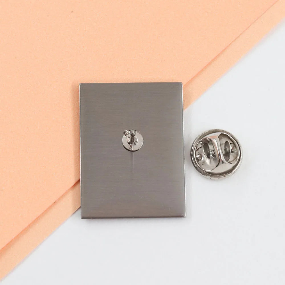Metallic square badge with a round pin on a two-tone background