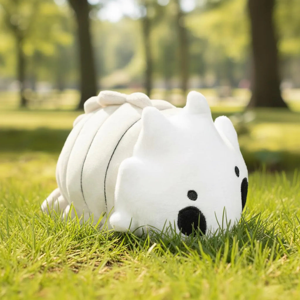 The Bell Beast Plush Toy sitting on the grass