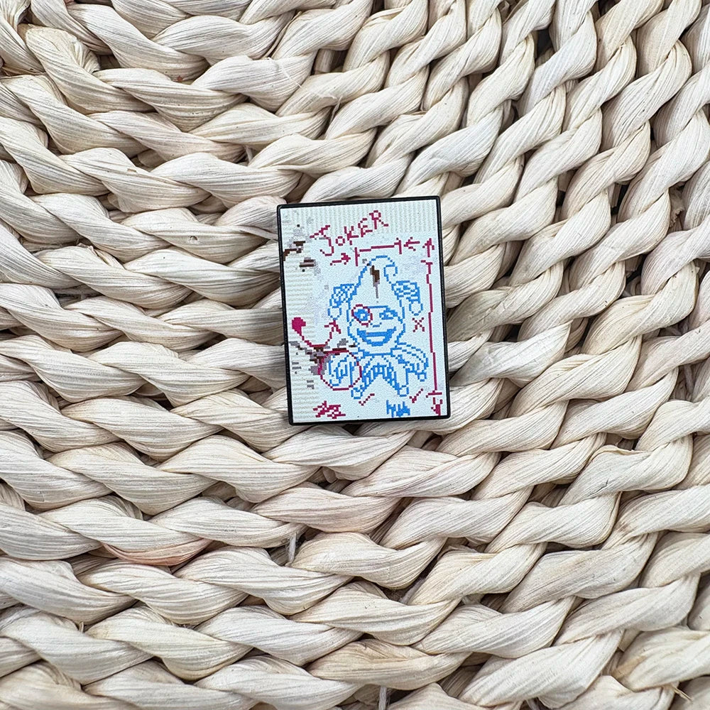Cross-stitched patch of a ghost with 'Brainstorm Joker' design on a woven surface