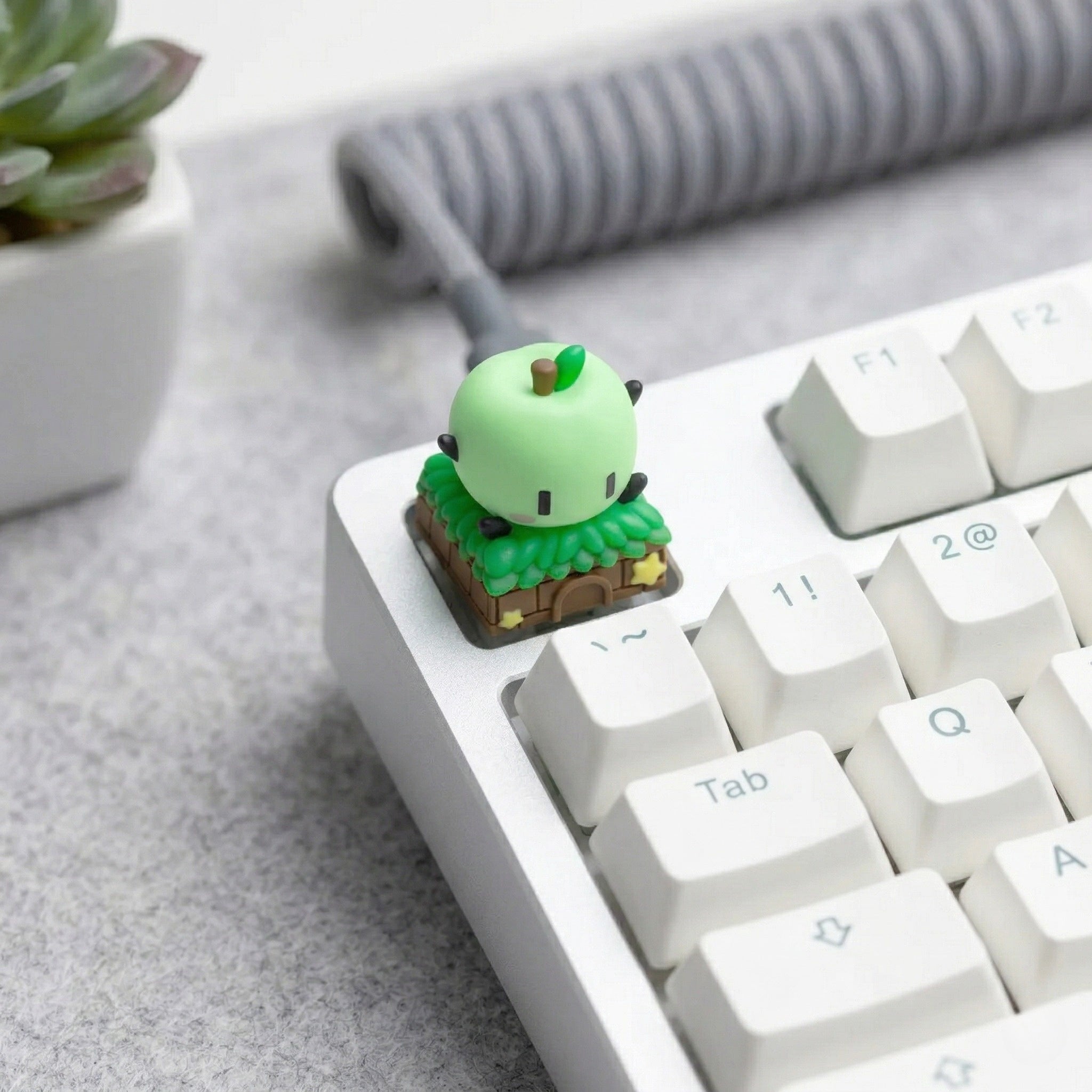 A cozy gaming setup featuring a Junimo Stardew Valley Keycap as a decorative escape key