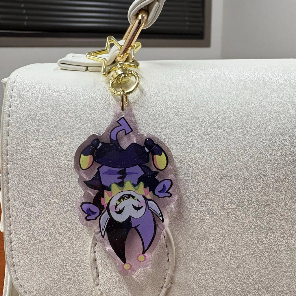 DELTARUNE Merch Jevil Keychain clipped onto a handback, demonstrating its use as a bag accessory.