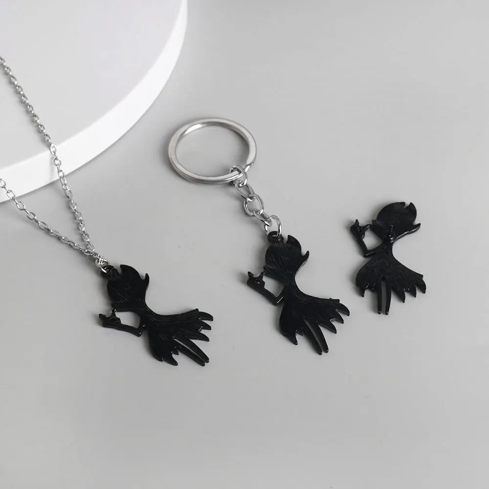 Close-up showing the back of Hollow Knight Grimm keychain attached to keys and the optional necklace chain.