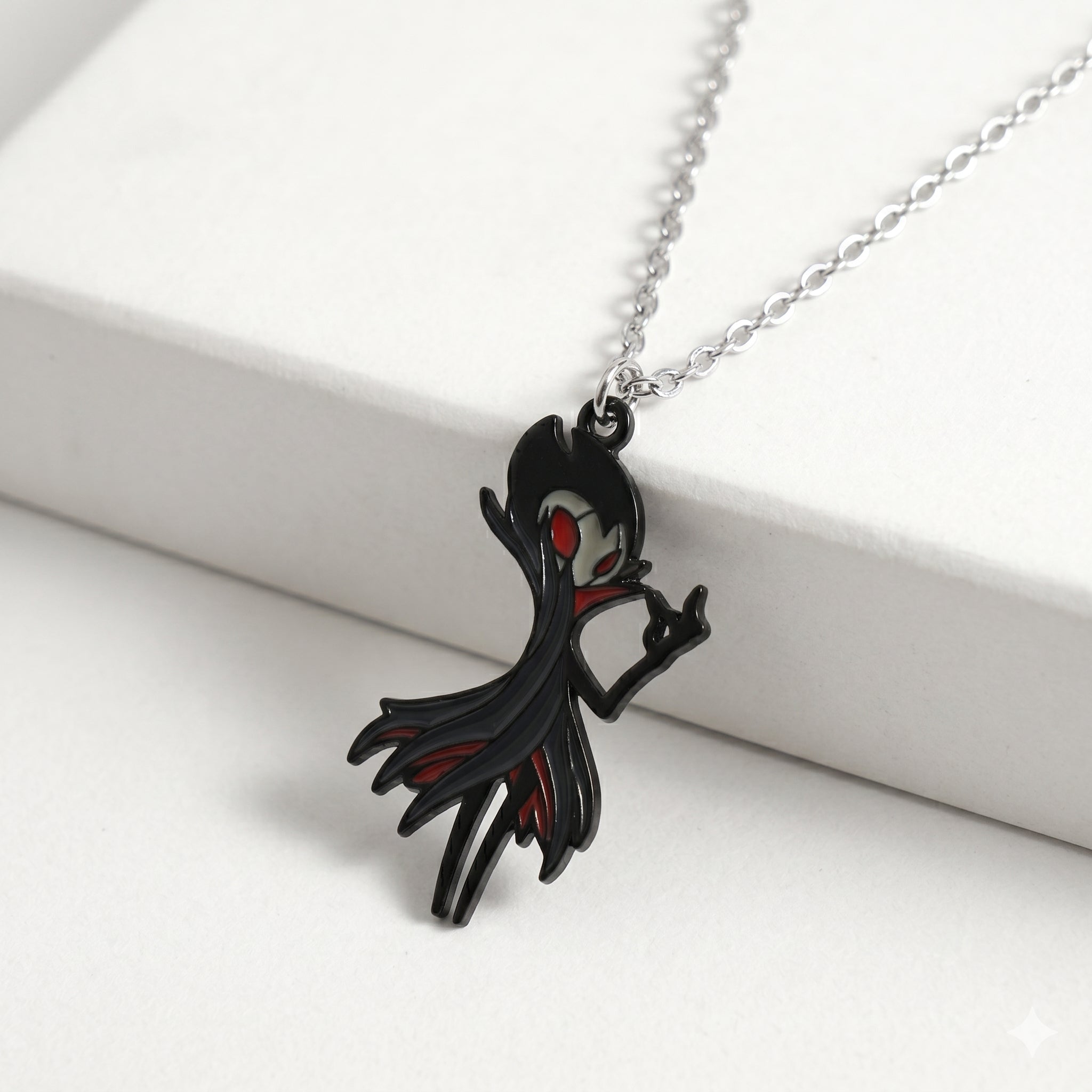Detailed close-up of the red and black enamel on the Hollow Knight Grimm keychain, necklace accessory.