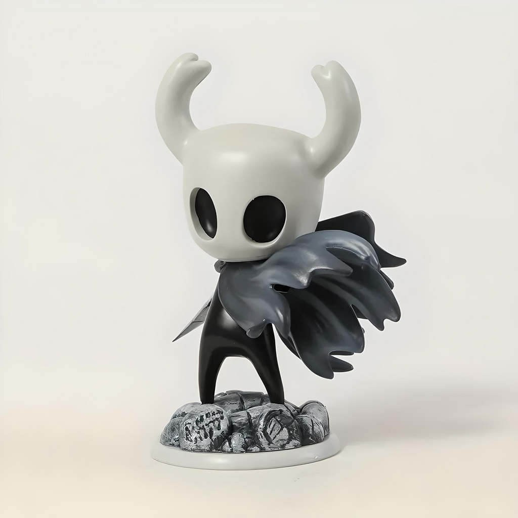 Hollow Knight action figure with white face, black wings, and horns on a light gray background