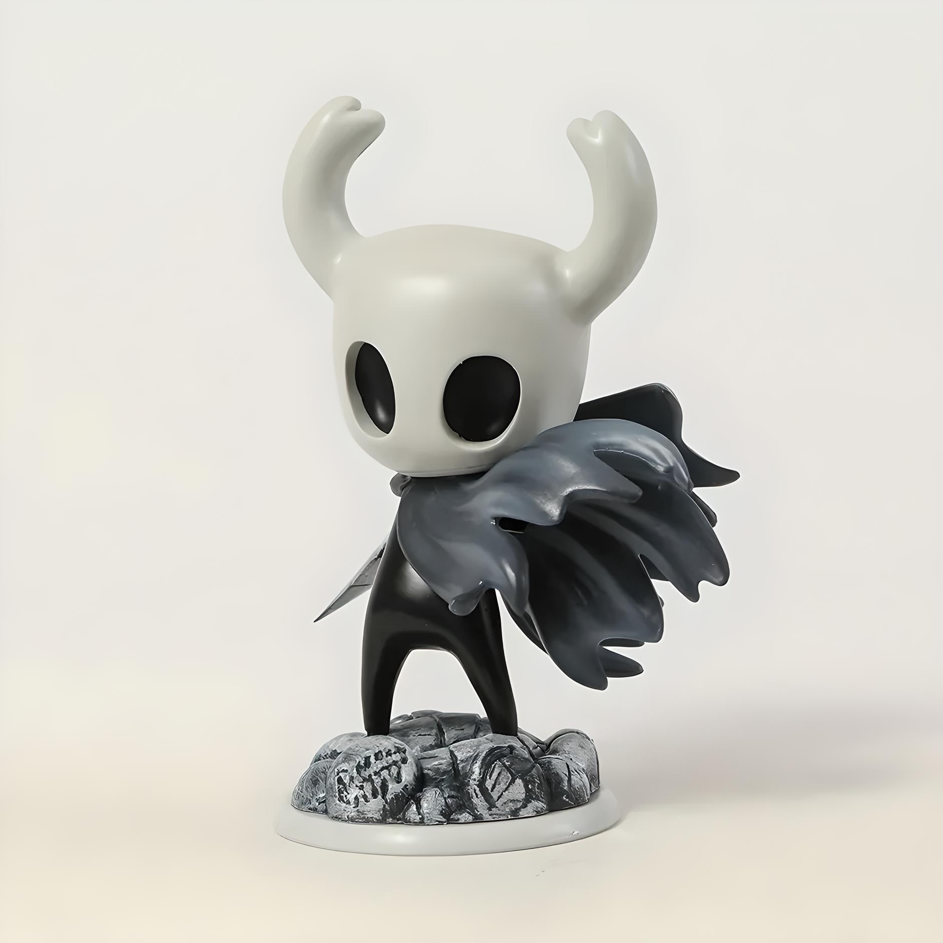Hollow Knight action figure with white face, black wings, and horns on a light gray background