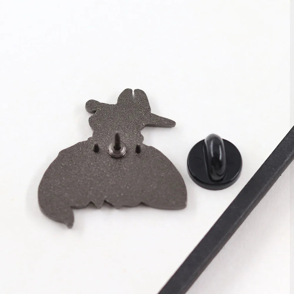 Back view of the Hornet & Bell Beast enamel pin showing the secure rubber clutch backing and metal finish.