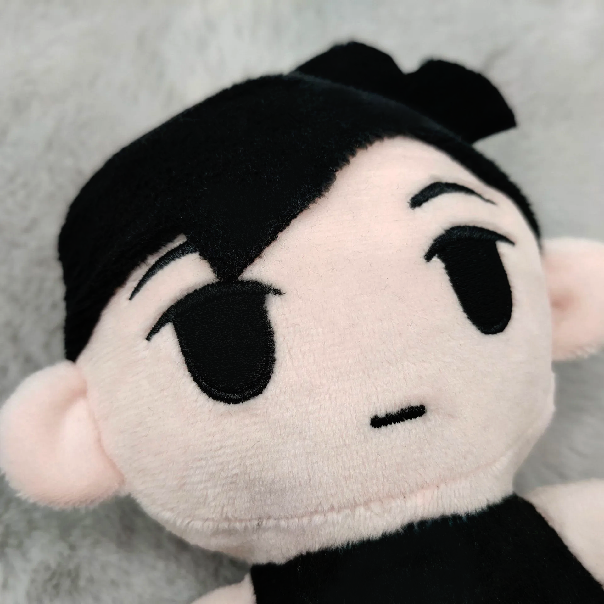Close-up of the OMORI Plush Toy's face and eyes, highlighting the detailed stitching and monochrome color palette.