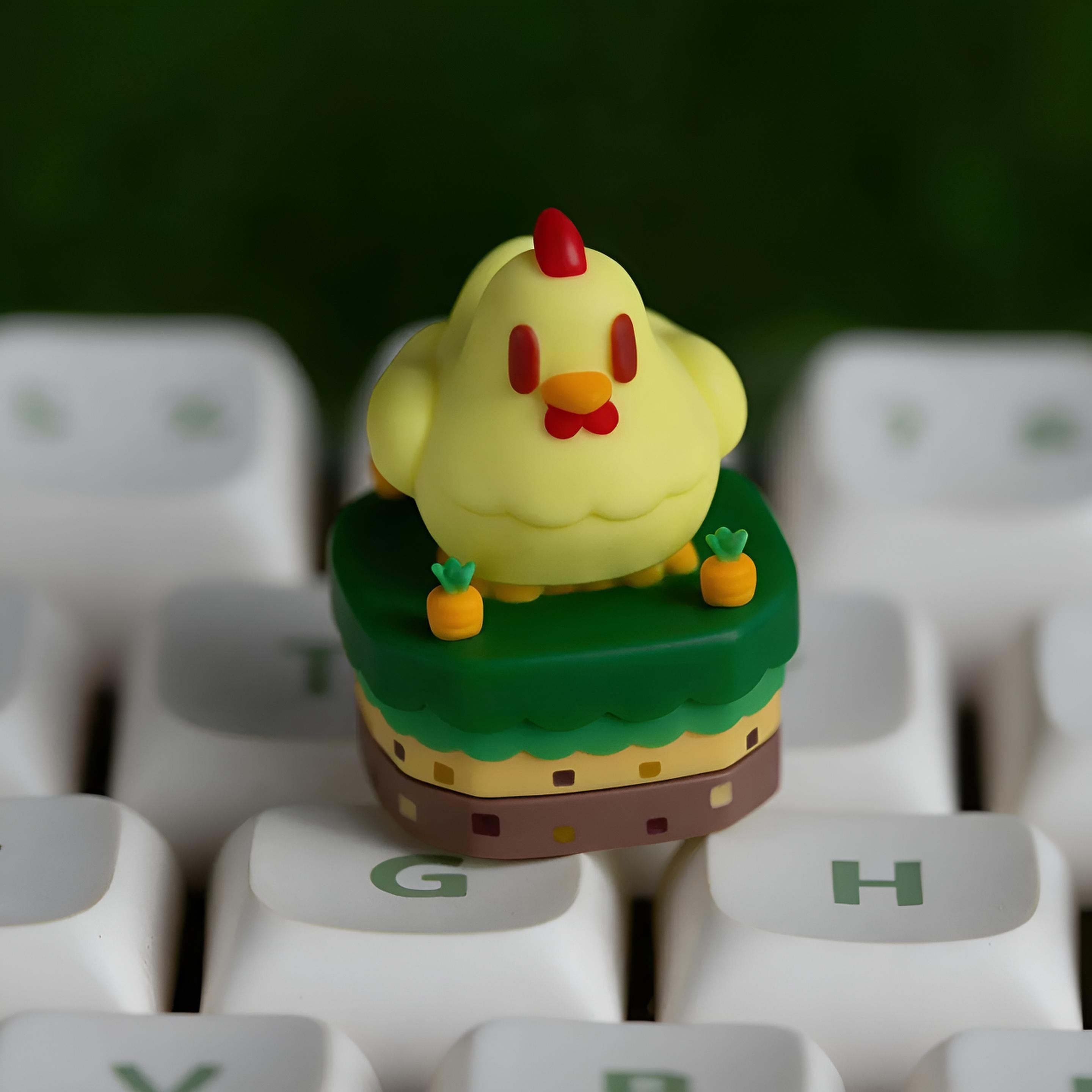 Stardew Valley Yellow chicken keycap on a green hill with carrots on a white keyboard