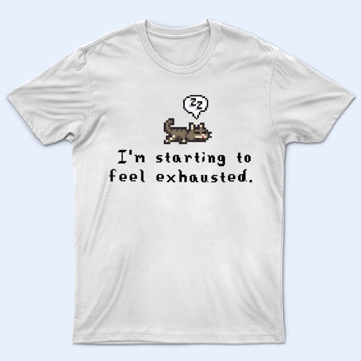 Mockup of a 'I'm starting to feel exhausted' Stardew Valley t-shirt, featuring text and an adorable sleeping pixel dog