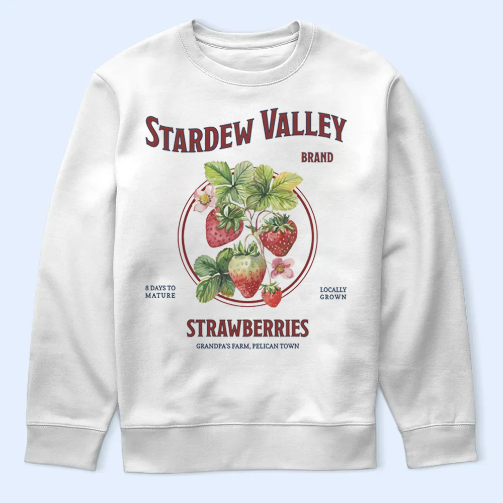 White sweatshirt with 'Stardew Valley' strawberry design on a light blue background