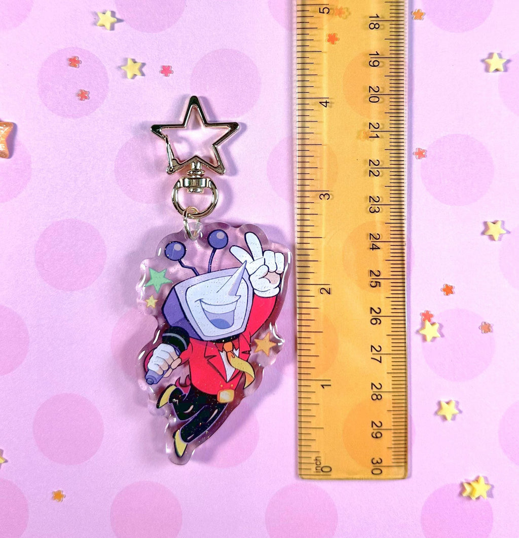 Tenna Deltarune Glitter Keychain held next to a key or coin for size reference, highlighting its scale.