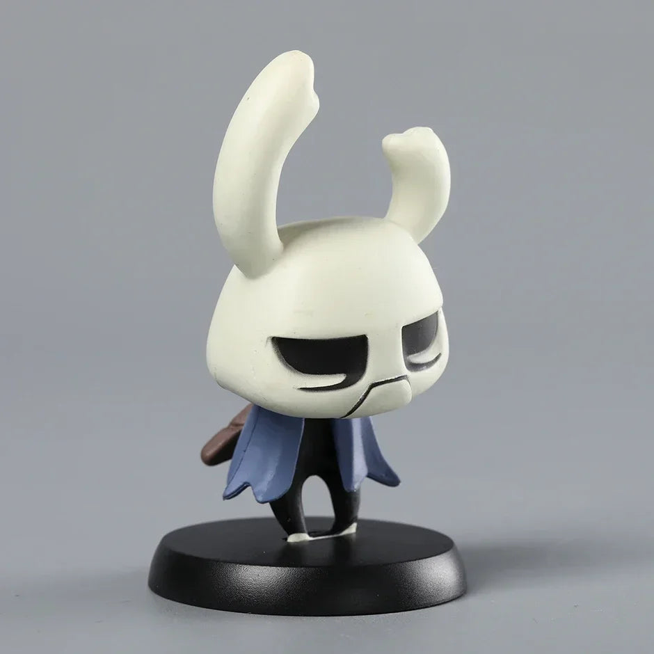 The Zote Mini Figure placed on a bookshelf next to other collectibles, showcasing its use as a charming desk ornament.